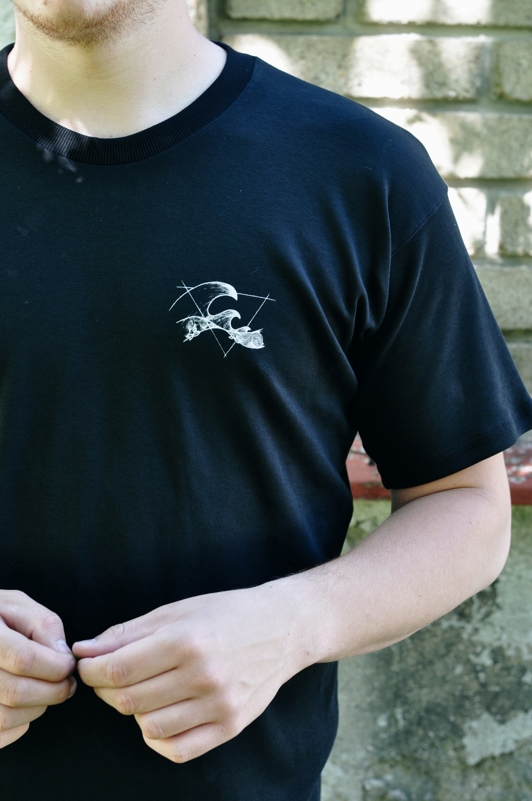 Biobavlněné unisex triko v černé barvě s potiskem majáku - přední díl, detail potisku. Biobavlněné unisex triko v černé barvě s potiskem majáku.