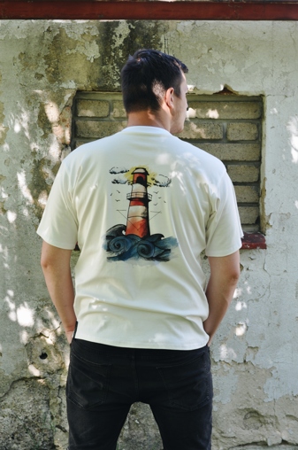 Biobavlněné unisex triko v bílé barvě s potiskem majáku - zadní díl. Biobavlněné unisex triko v bílé barvě s potiskem majáku.